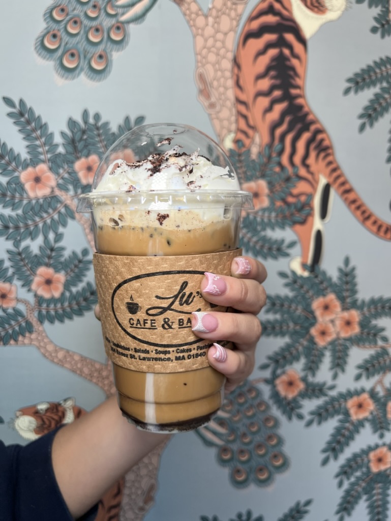 Iced coffee topped with whipped cream and cookie crumble at Lu's