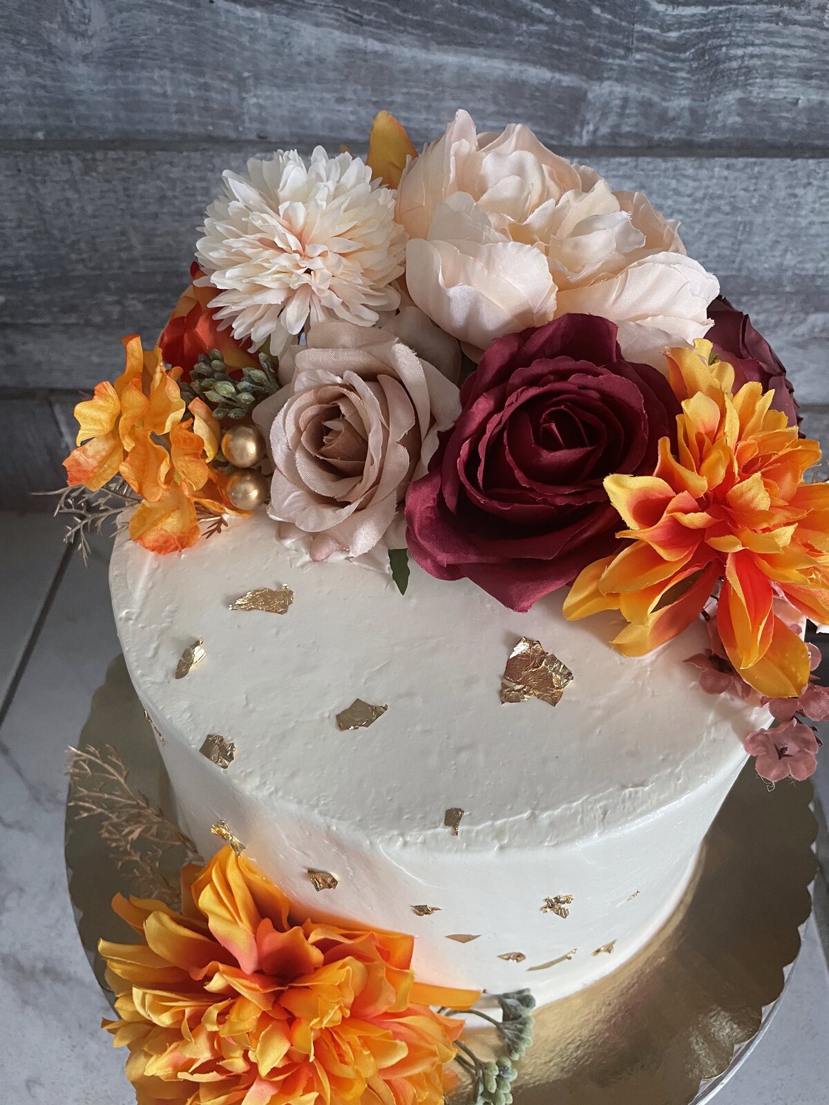 Elegant white floral custom cake with gold leaf at Lu's Cafe & Bakery