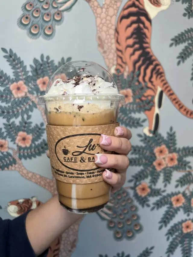 Iced coffee topped with whipped cream and cookie crumble at Lu's