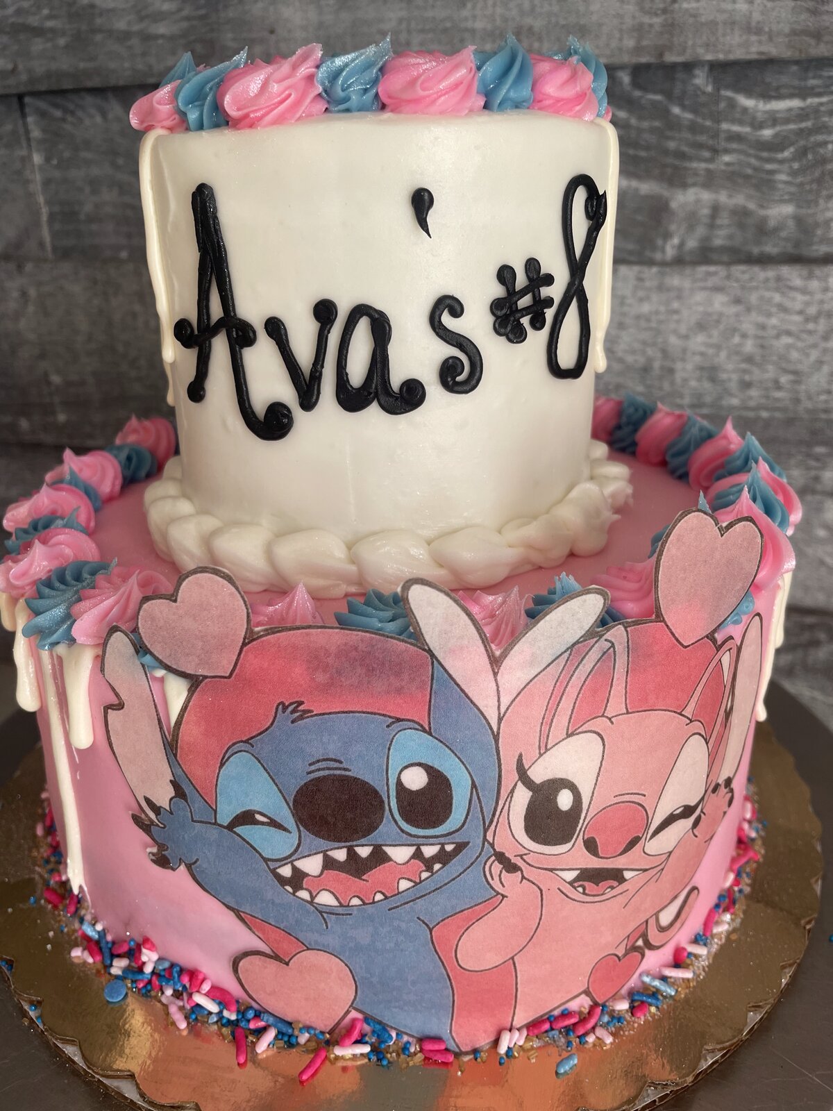 Tiered pink cake with cartoon characters at Lu's