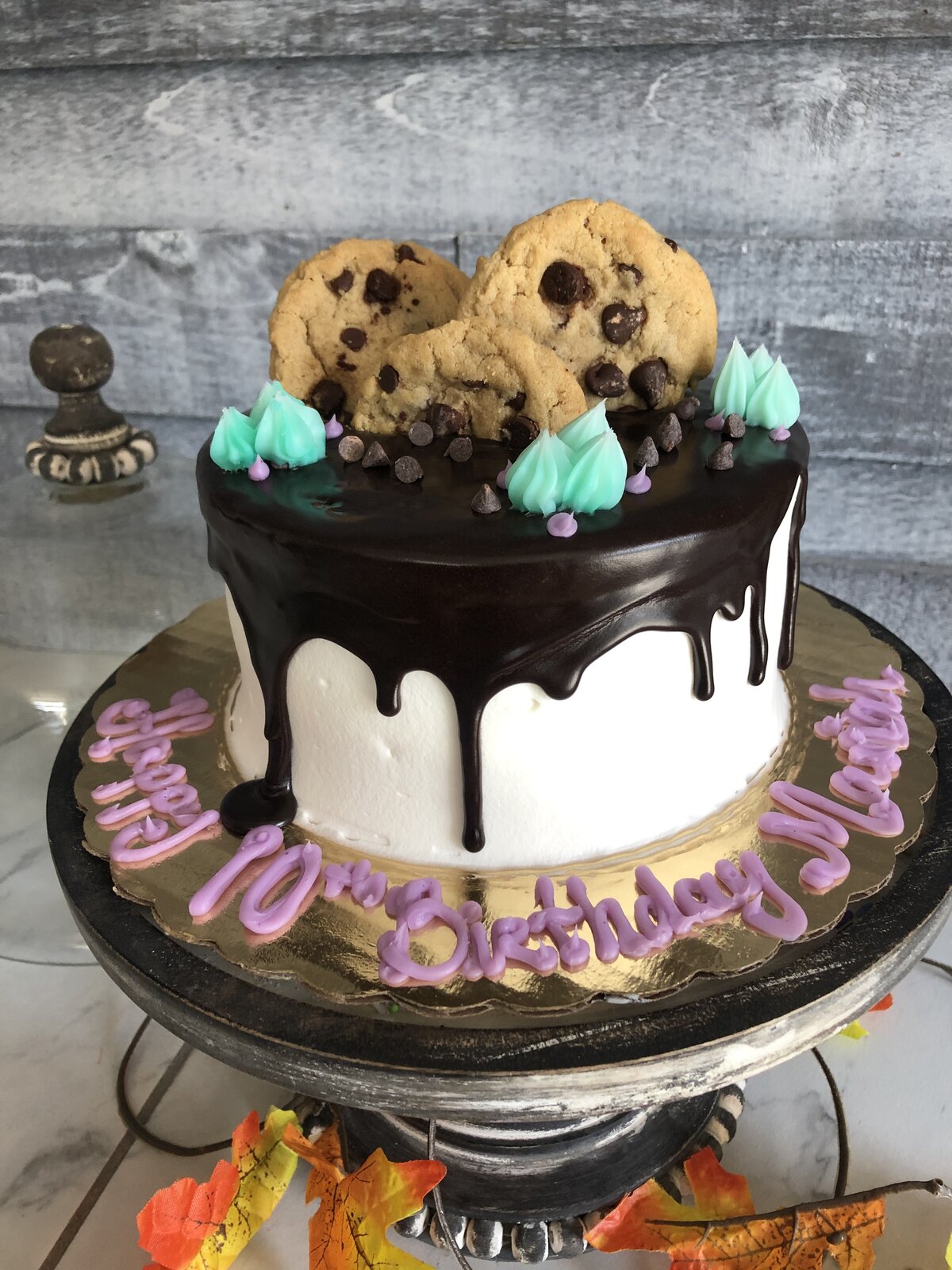 Chocolate drip cake topped with cookies at Lu's